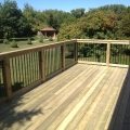 Pressure-treated deck with 5x5 railing posts and black rod railing