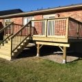Pressure-treated deck with black rod railing