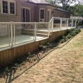 Pressure-treated deck and skirting with Regal glass railing with picket