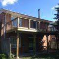 Pressure-treated deck with 5x5 railing posts and black rod railing