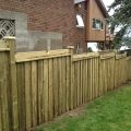 6-foot board and batten style fence with 2x6 custom top, 5x5 posts on decline